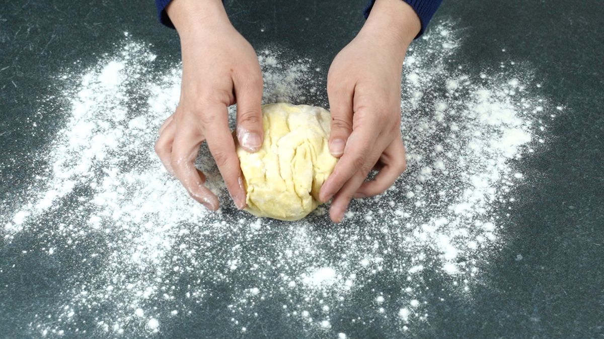 hands kneading dough ball