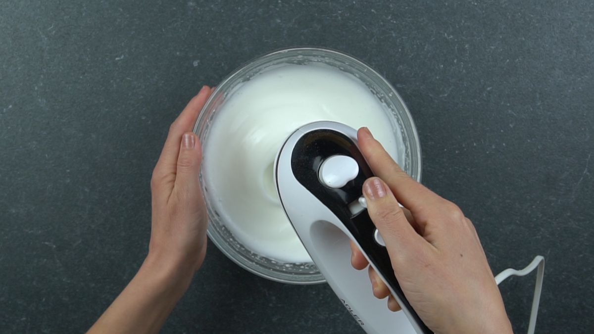 hand mixer in glass bowl of egg whites