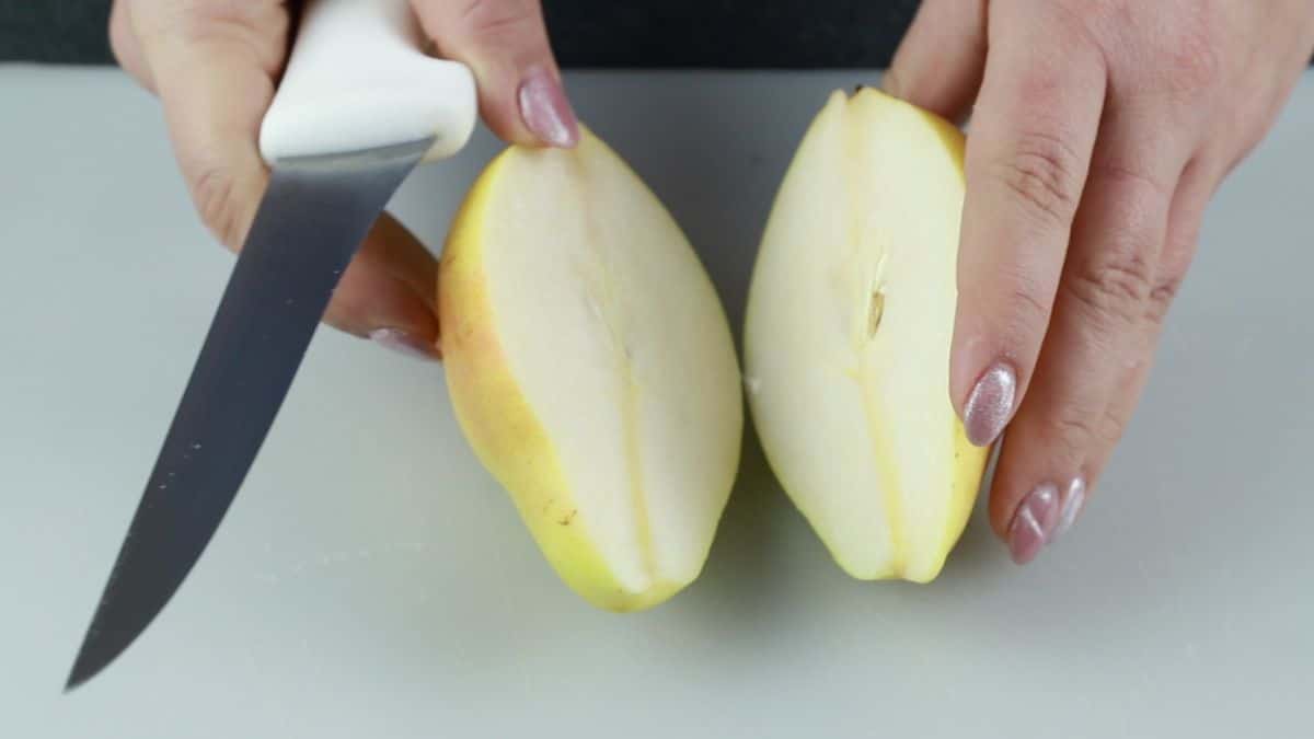 hand pulling apart sliced pear