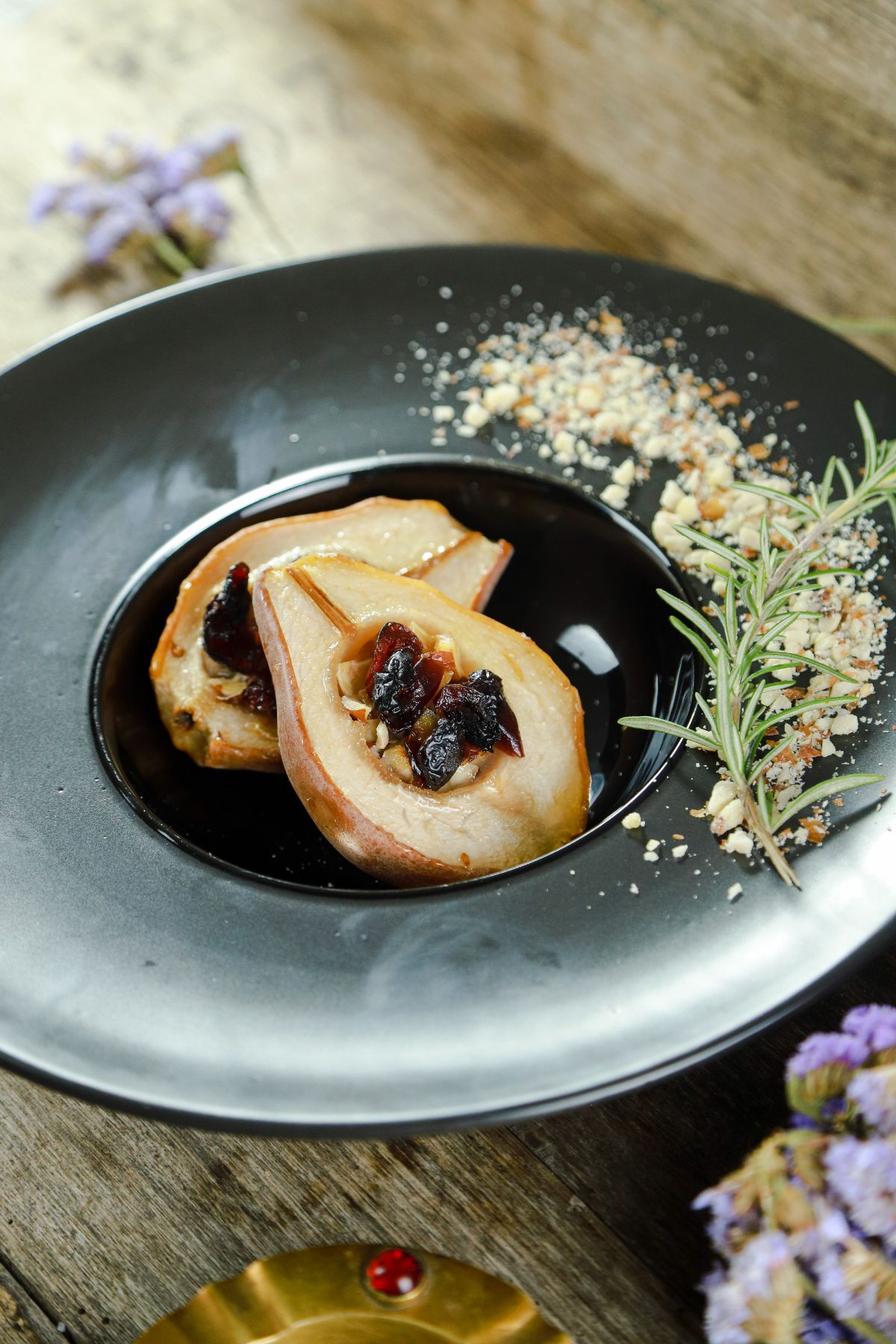 round black plate with stuffed pears in center and nuts with fresh rosemary on edge of plate