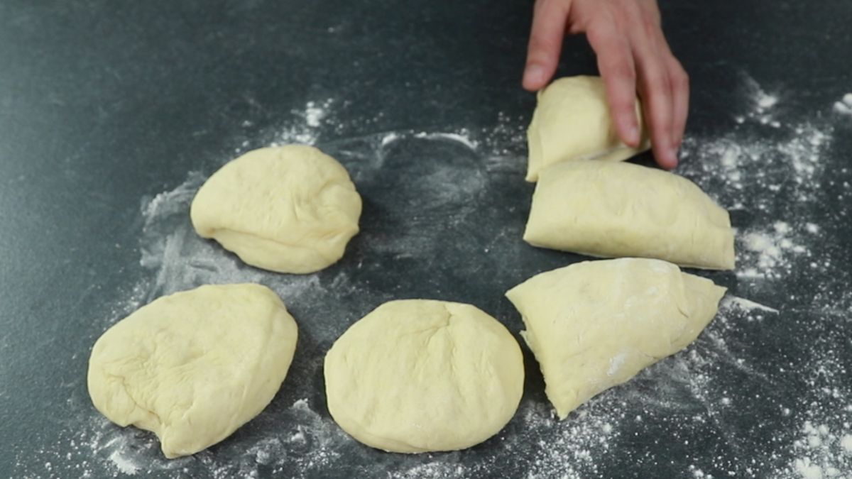 6 pieces of dough on floured gray surface