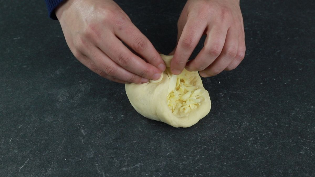 dough being folded over cheese