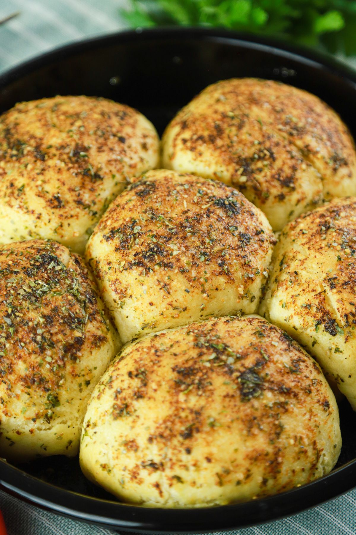 close up image of garlic cheesy bread bombs on black plate