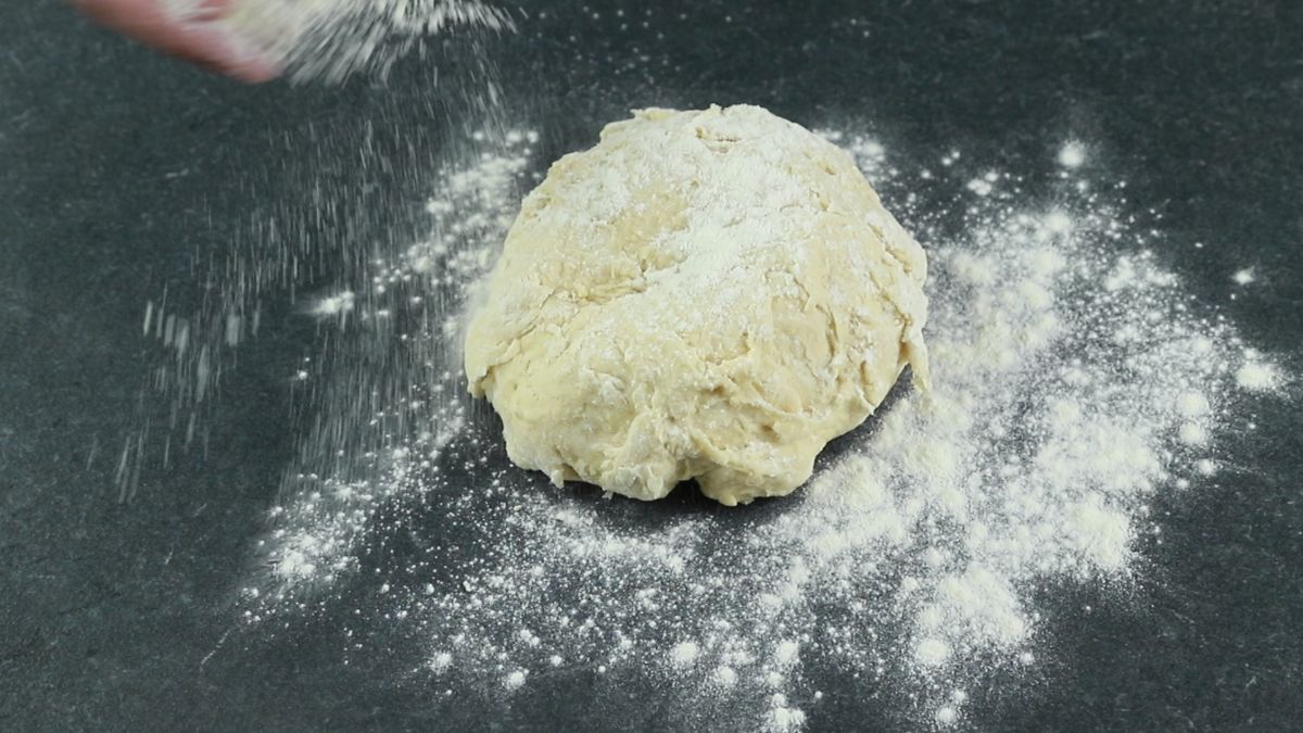 bread dough being poured onto floured surface