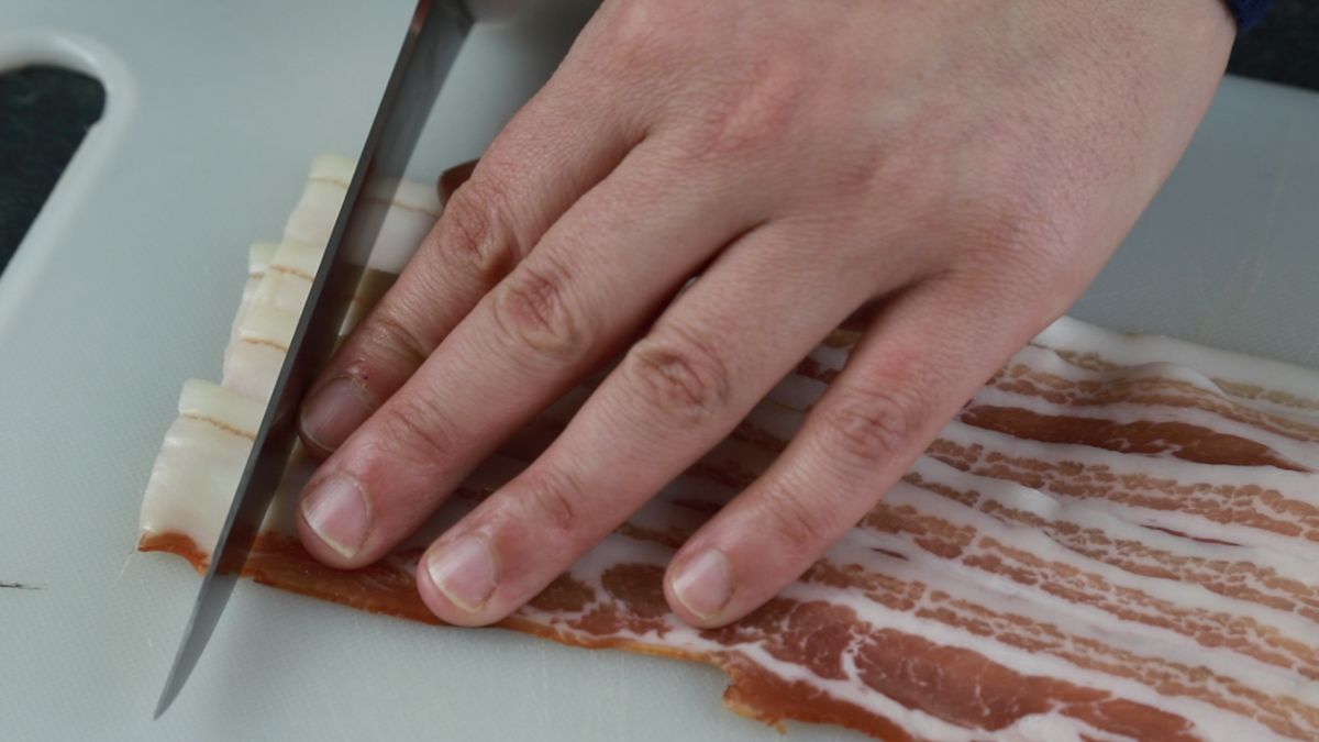 bacon being cut into pieces