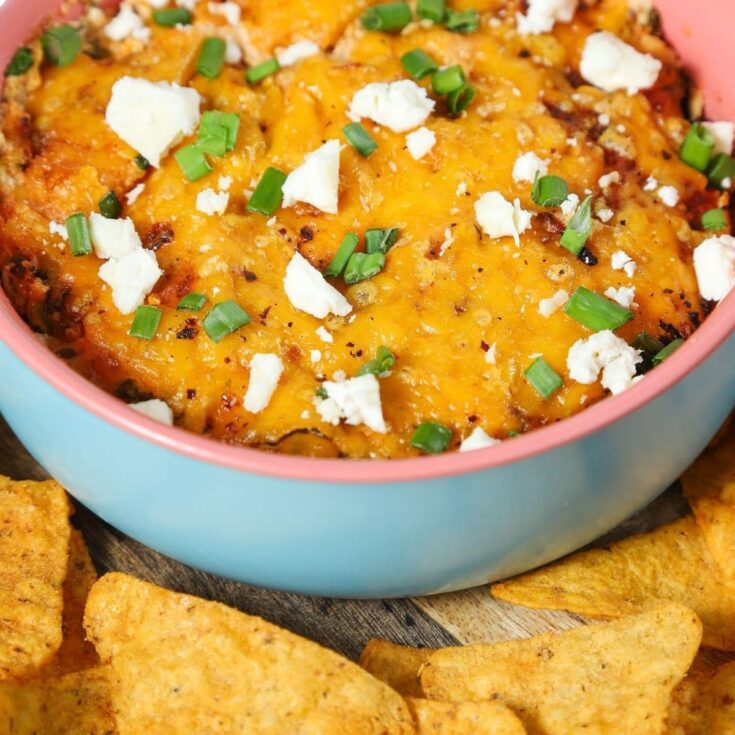 light blue bowl filled with buffalo chicken dip with chips on the side