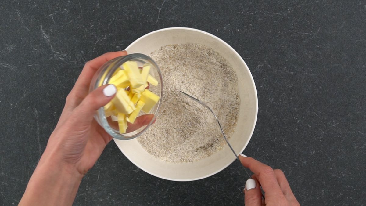 butter being poured into white bowl with