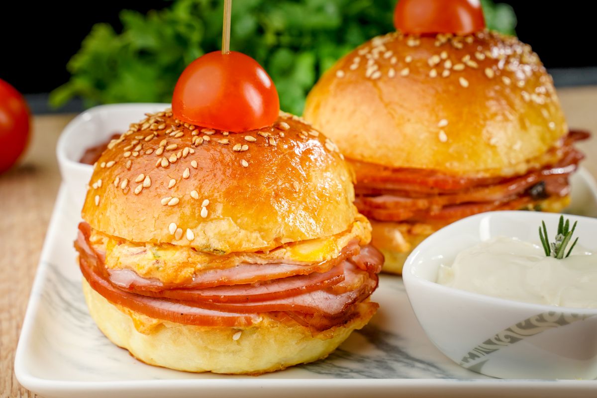 Sliders with tomatoes on top held down with toothpicks