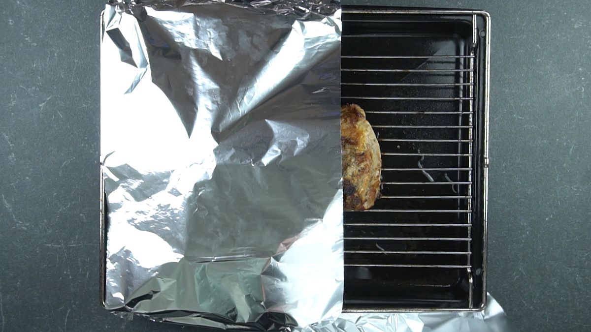 aluminum foil covering half of pork loin