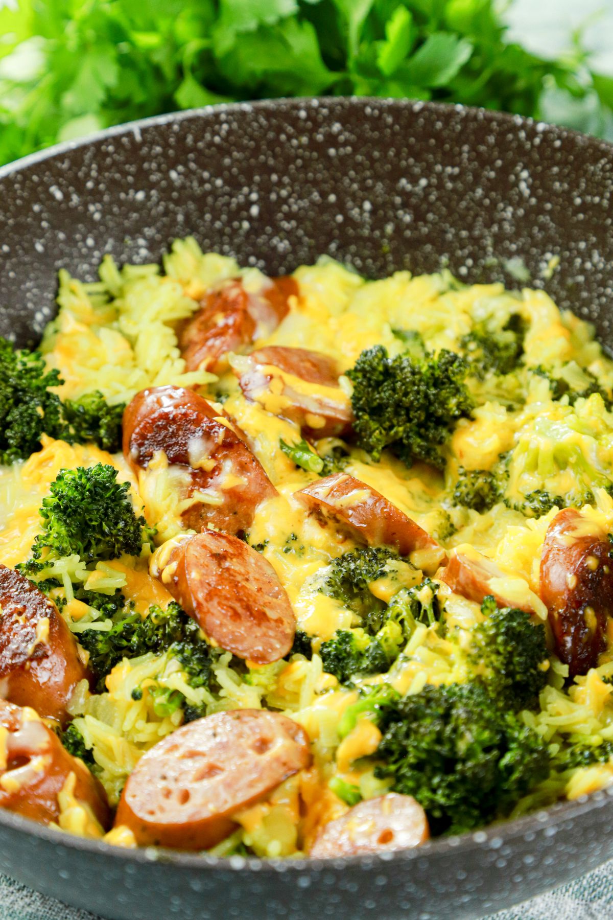 rice sausage and broccoli in speckled black skillet