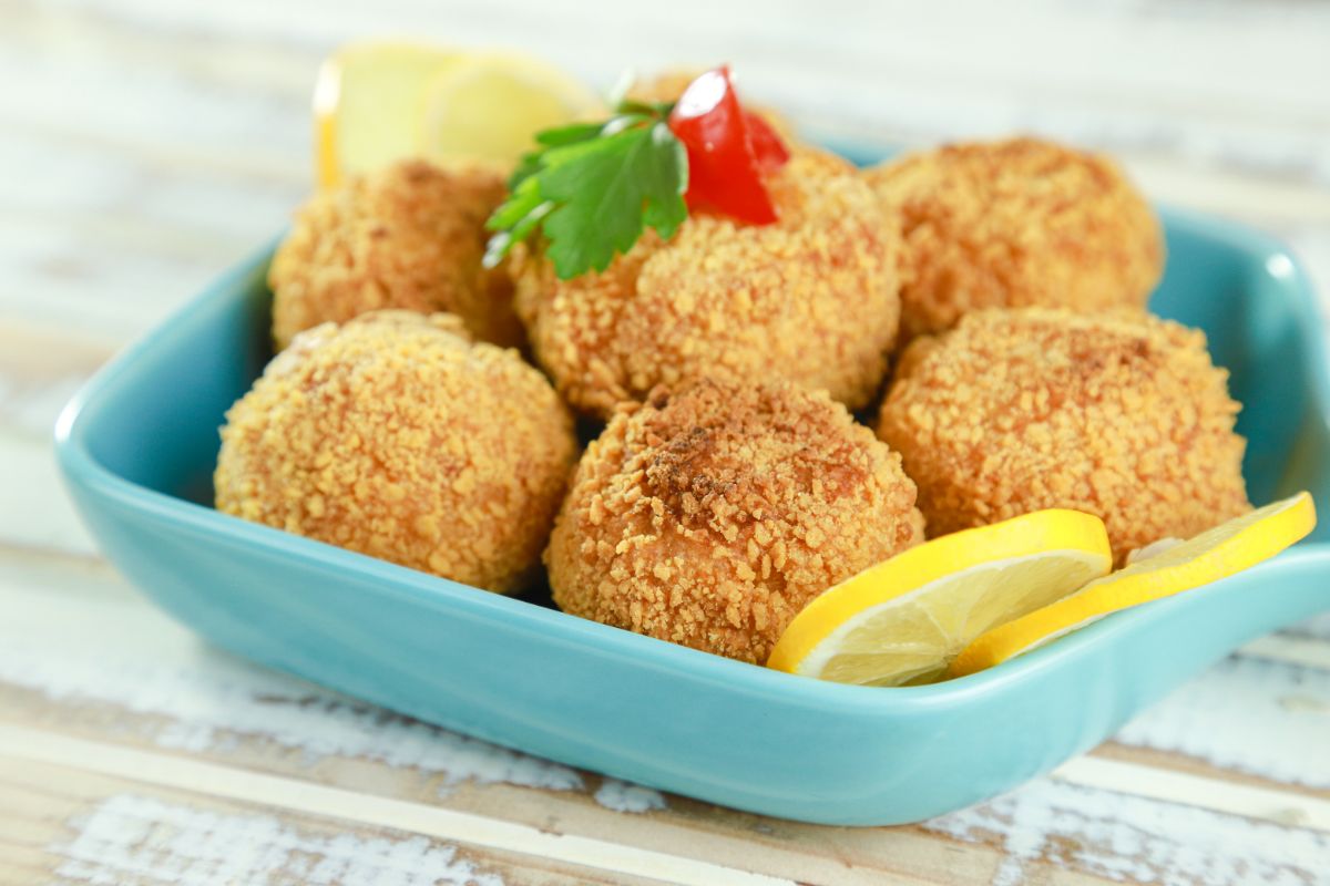 chicken balls in blue bowl with lemon slices