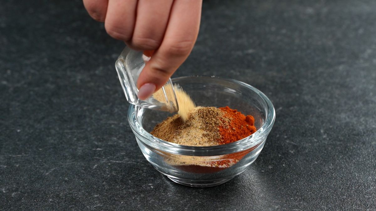 spices being combined in small glass bowl