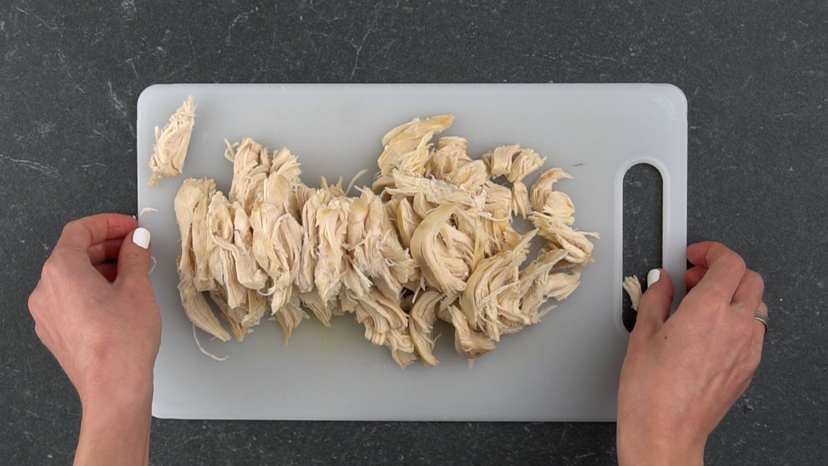 shredded chicken on white cutting board