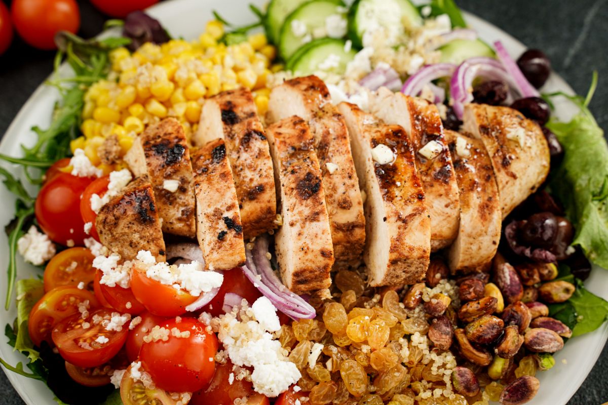 close up grilled chicken on salad with tomatoes and corn