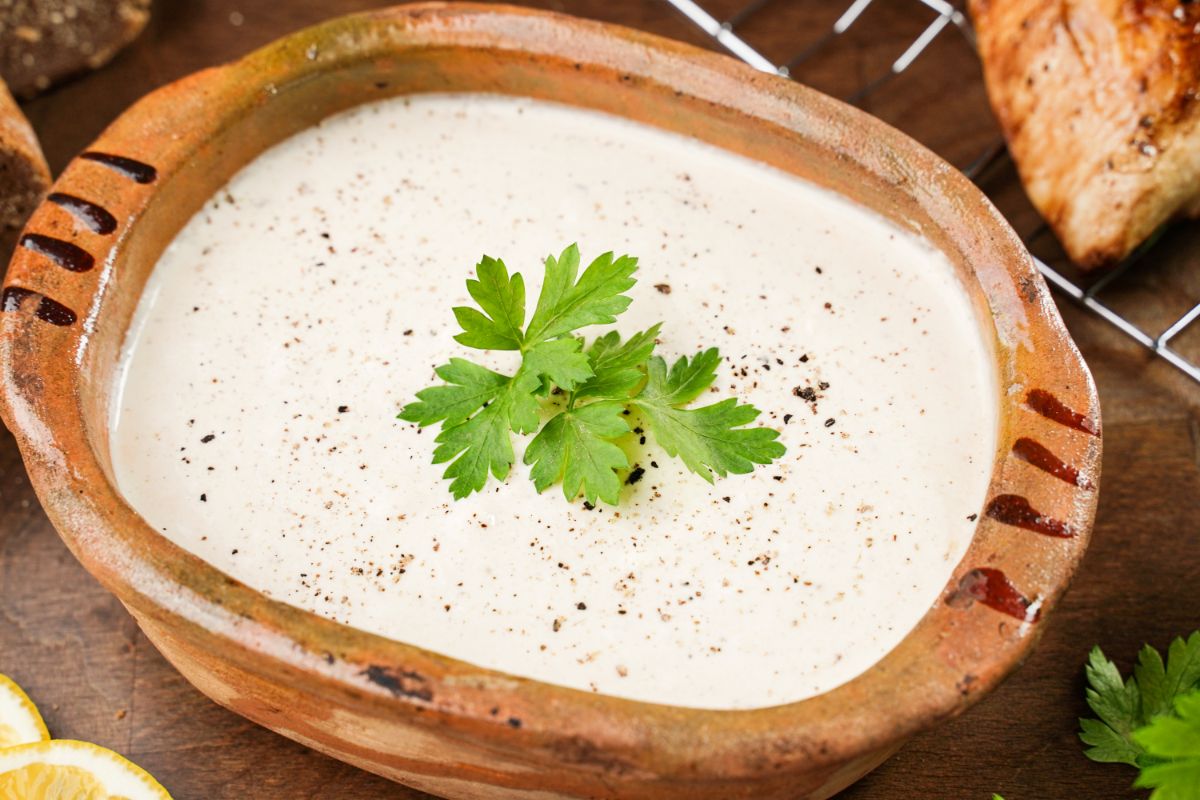 wooden bowl of sauce with parsley on top