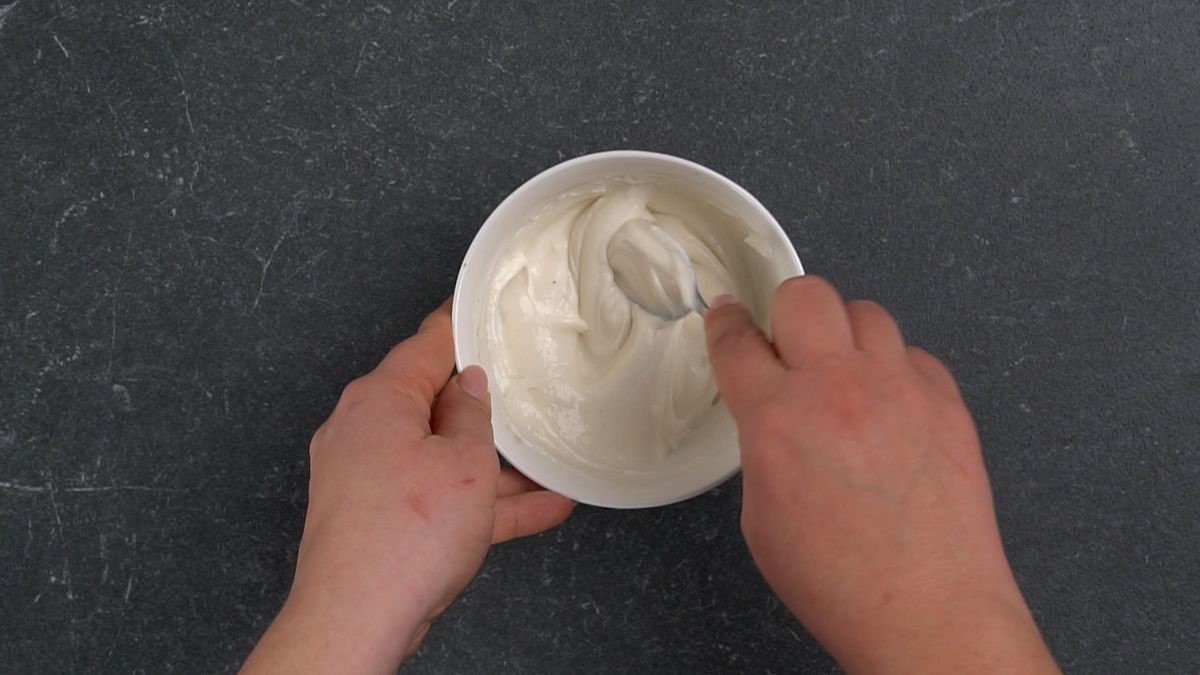 white bowl of cream cheese being stirred