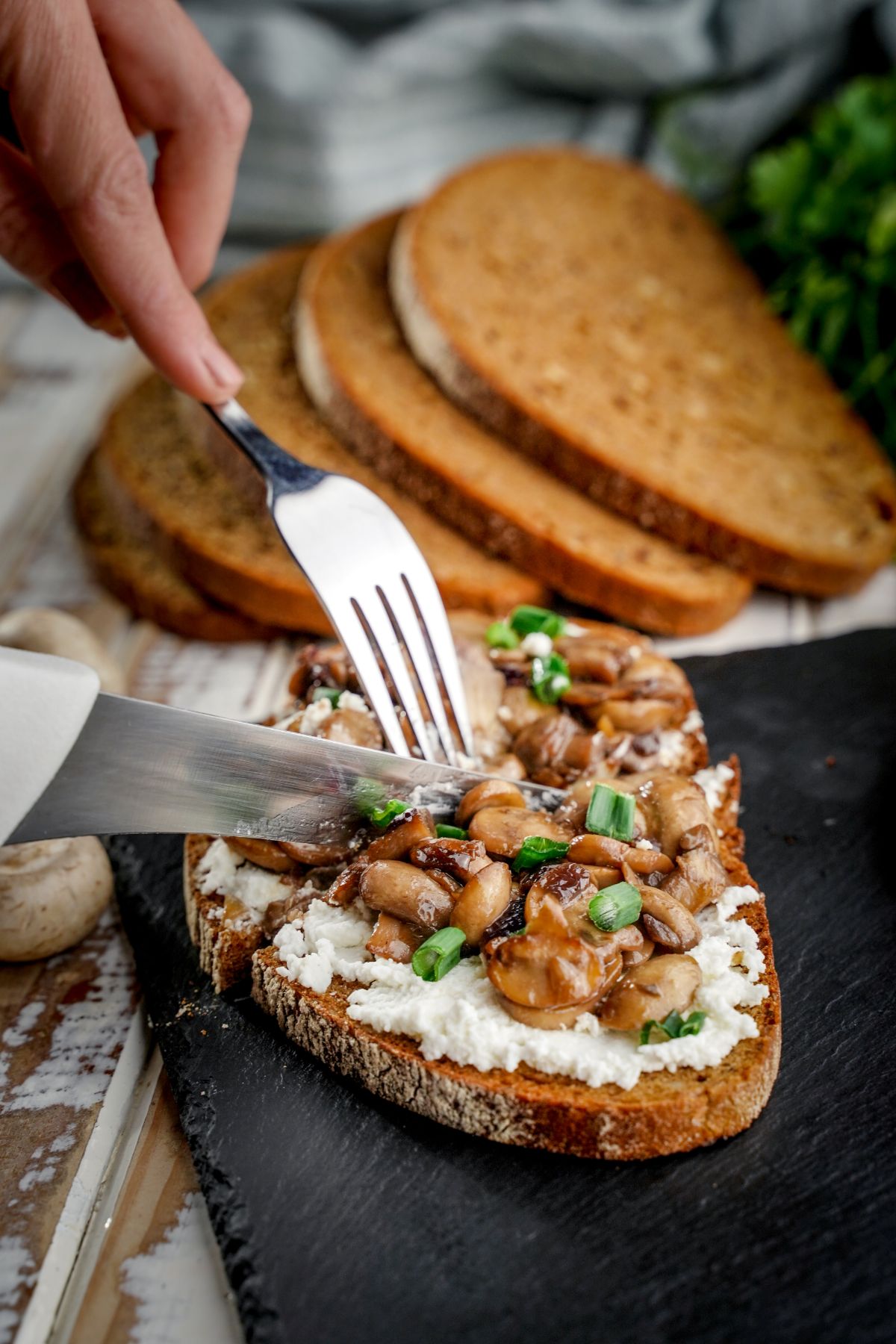 fork and knife cutting slice of mushroom toast