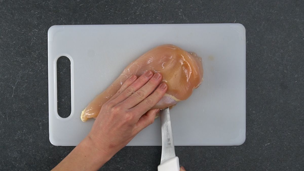 white knife slicing open chicken breast
