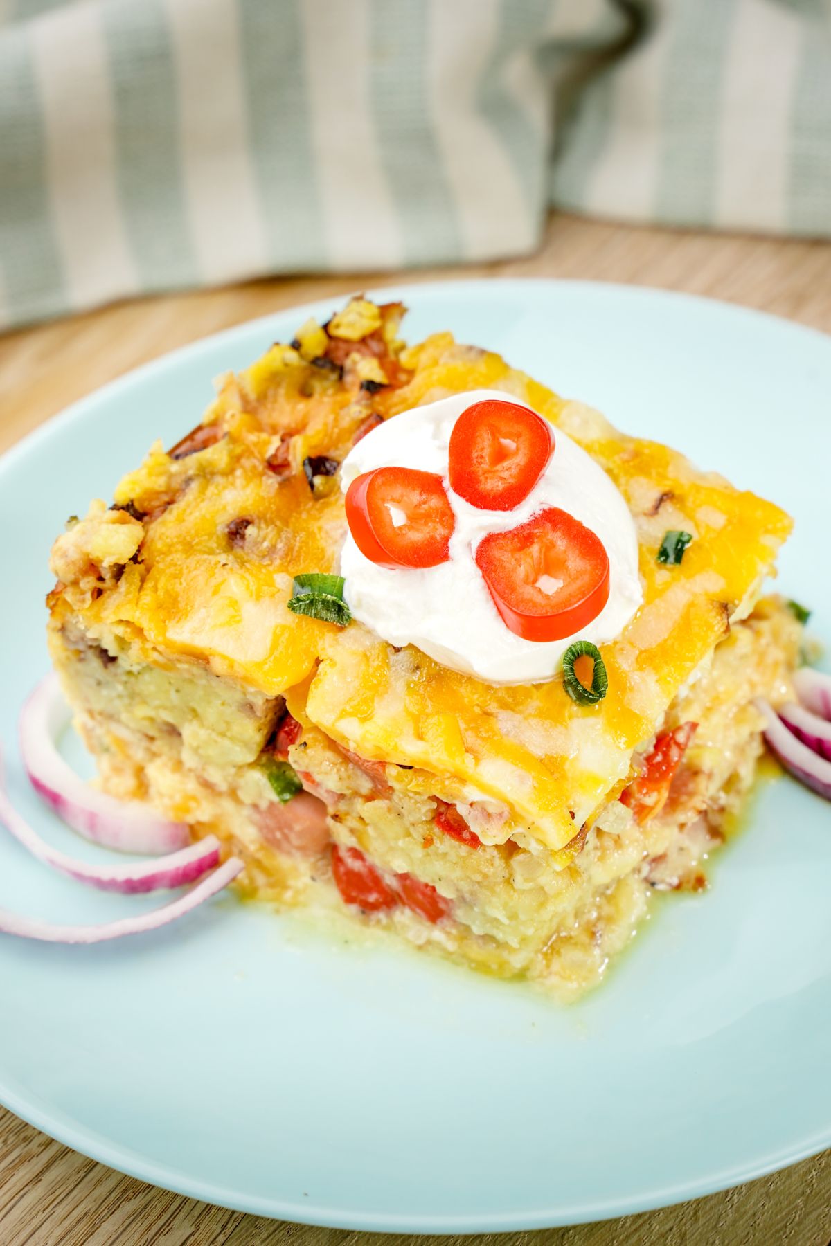 breakfast casserole on blue plate topped with sour cream