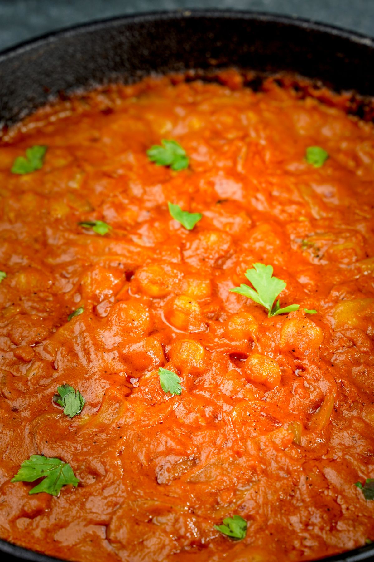 close up image of chickpea curry with cilantro on top