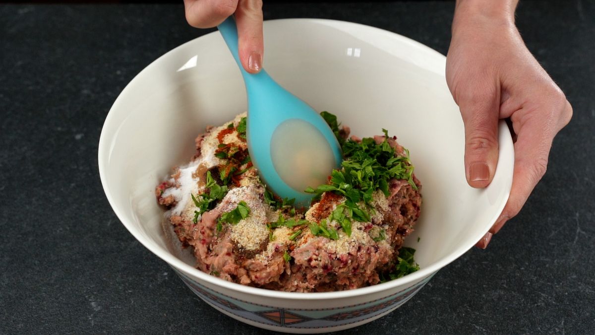 herbs and spices on top of impossible burger in white bowl