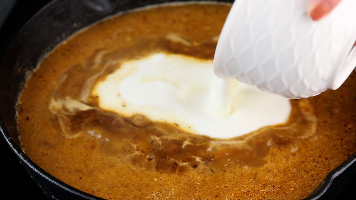cream being added to sauce in skillet