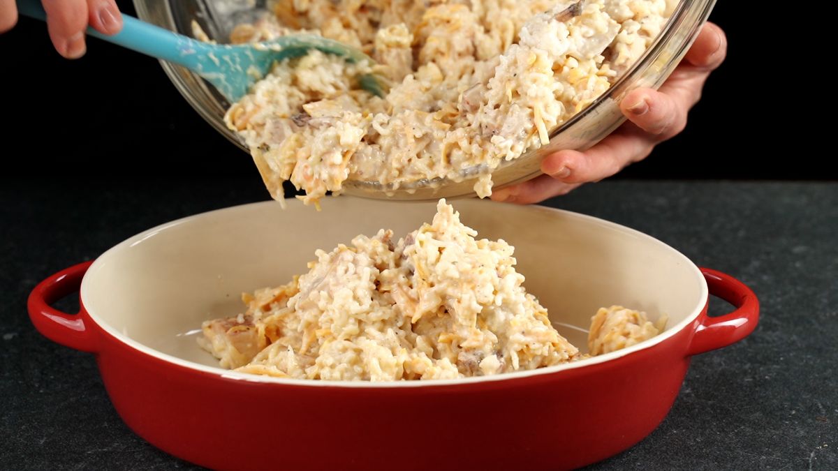 oval red dish with chicken and rice being poured into dish