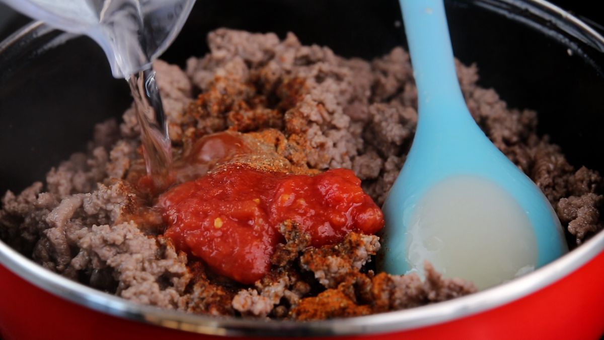 salsa being added to skillet with ground beef