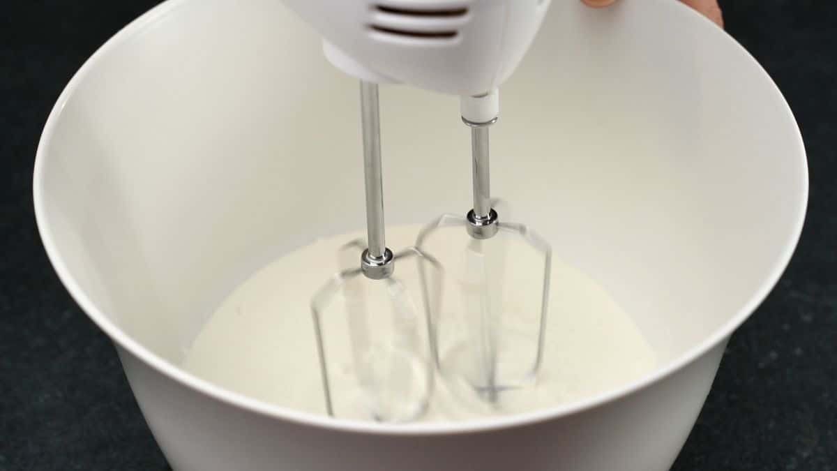 hand mixer in bowl of cream
