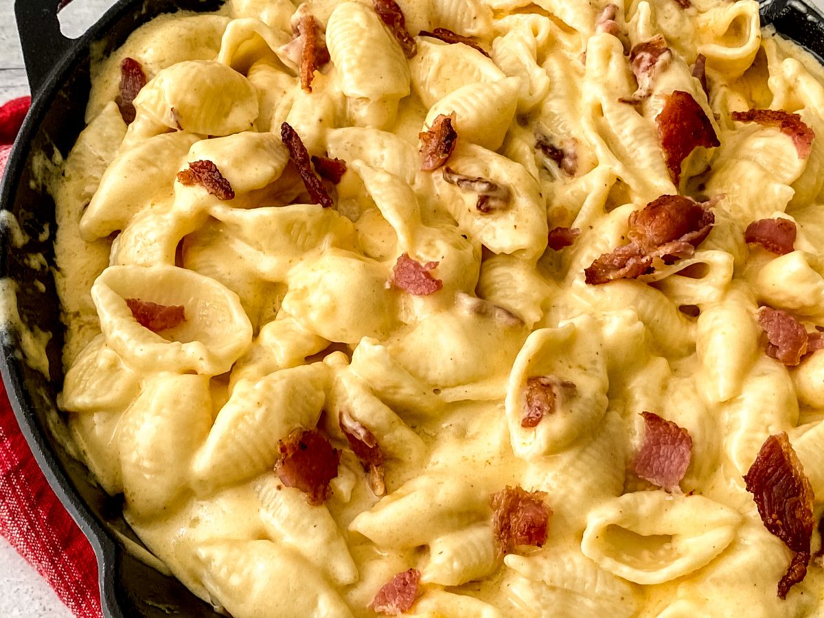 macaroni shells and cheese with bacon crumbles in cast iron skillet