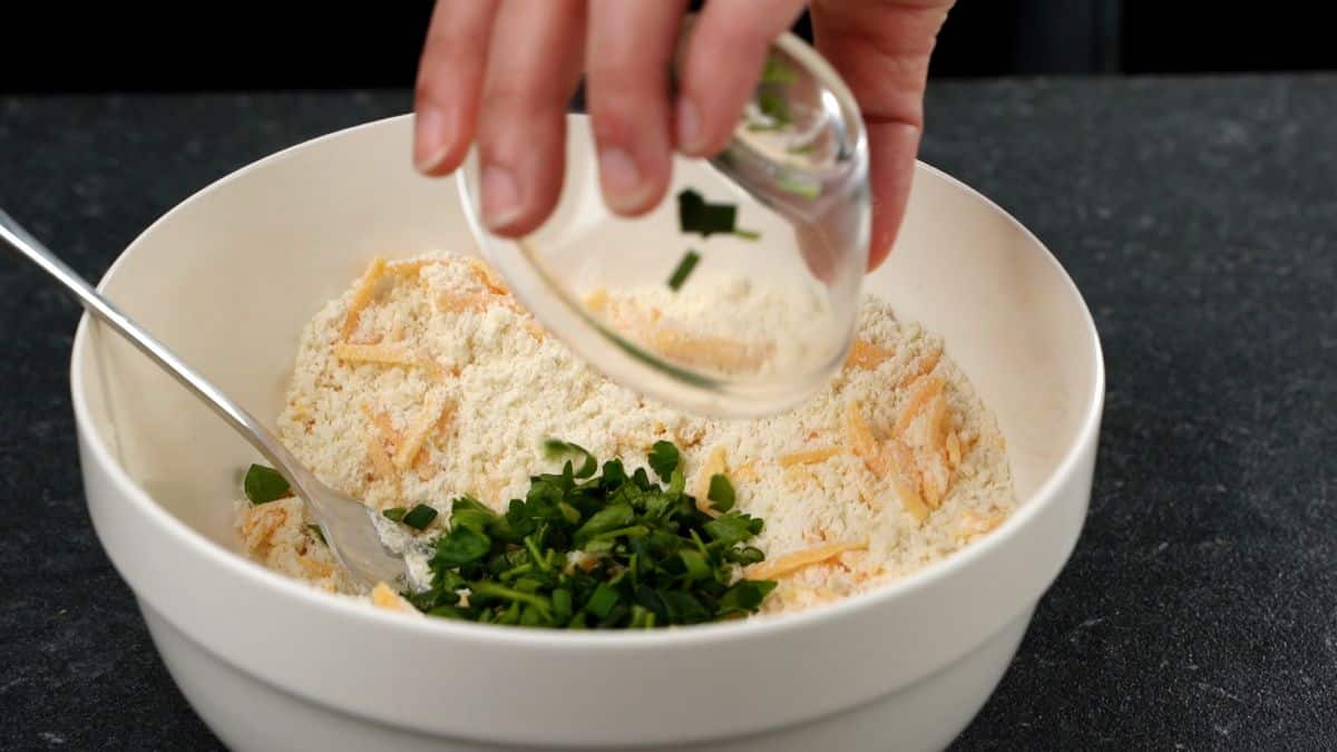 parsley being added to bowl of cheese and flour