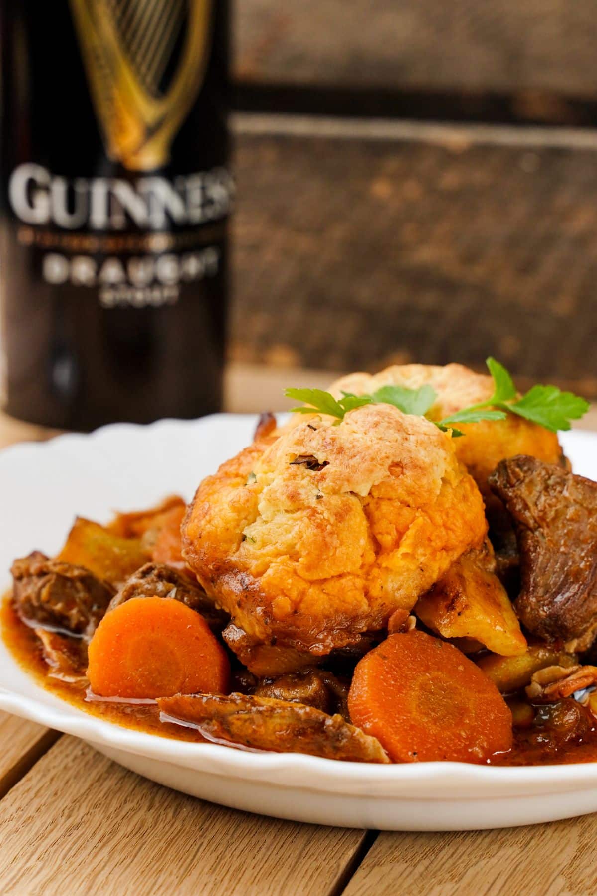 white bowl of stew on counter with guinness in background