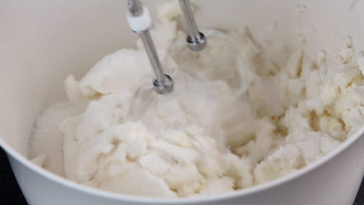 cream cheese being beaten in white bowl