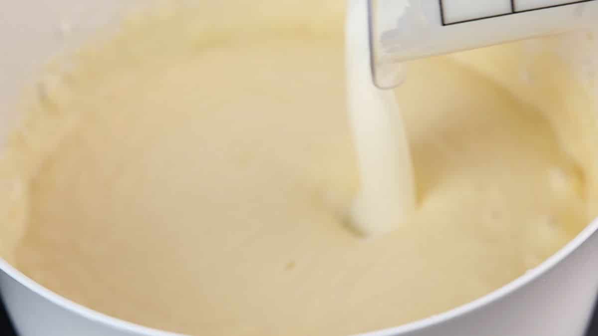 cream being poured into cheesecake