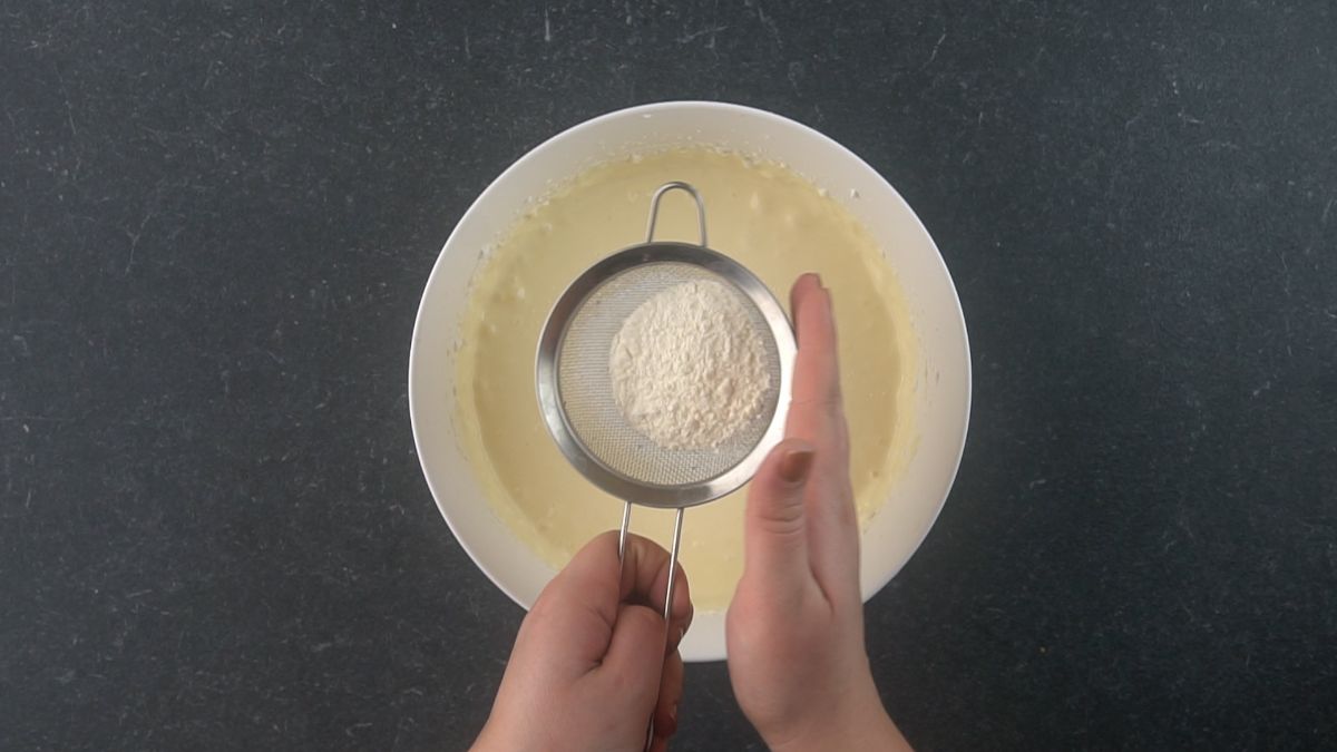 flour being sifted into cheesecake