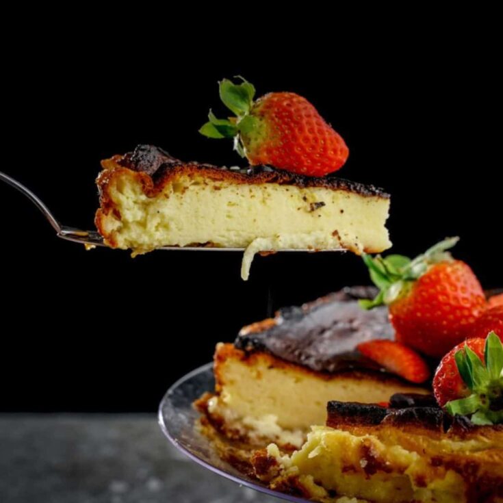 slice of cheesecake on cake stand with black background