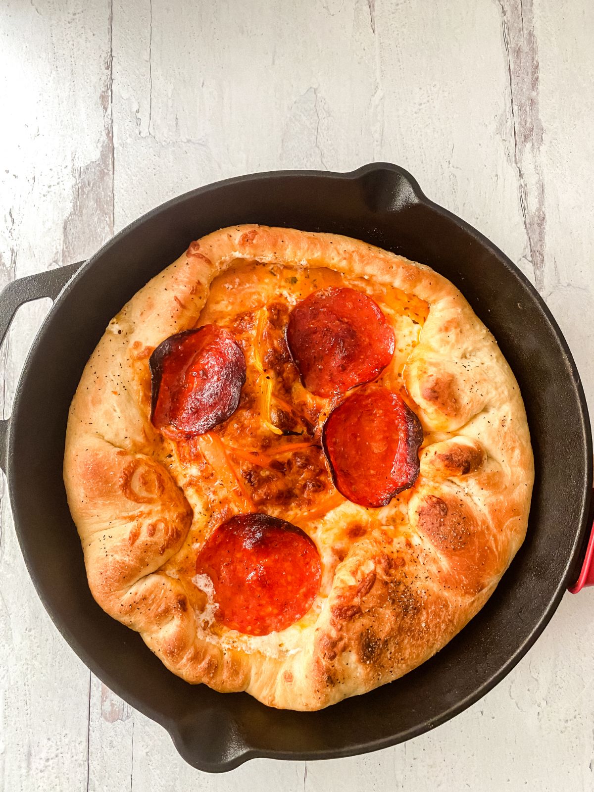 cast iron skillet of pizza on marble counter