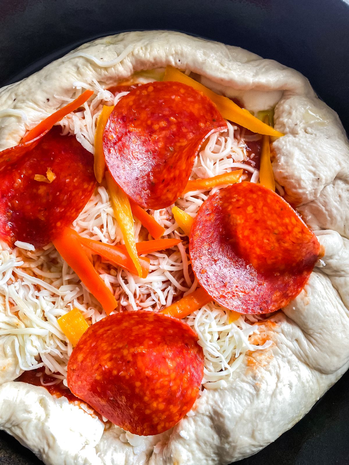 pepperoni on top of pizza in skillet