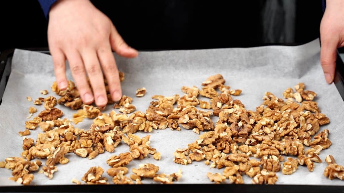 walnuts on parchment paper lined baking sheet
