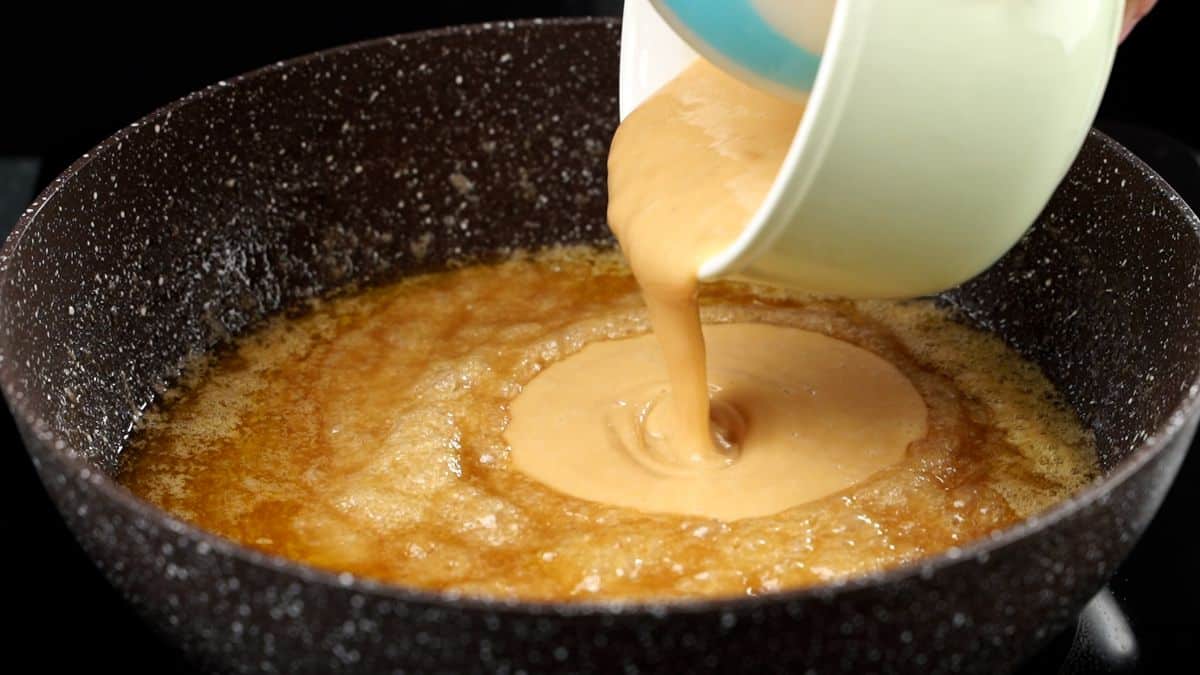 condensed milk being poured into skillet with caramel