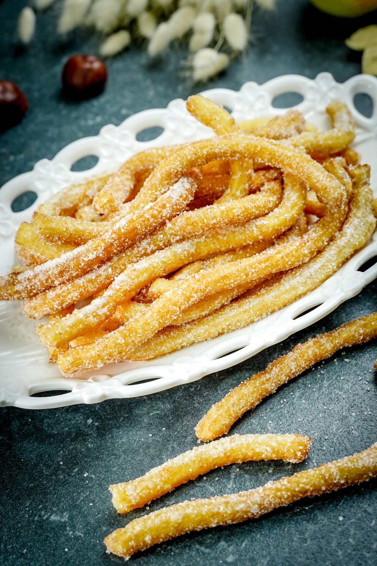 oval white plate of churros sitting on black table