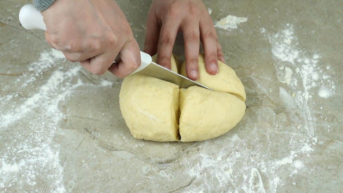 knife cutting dough into 4 pieces