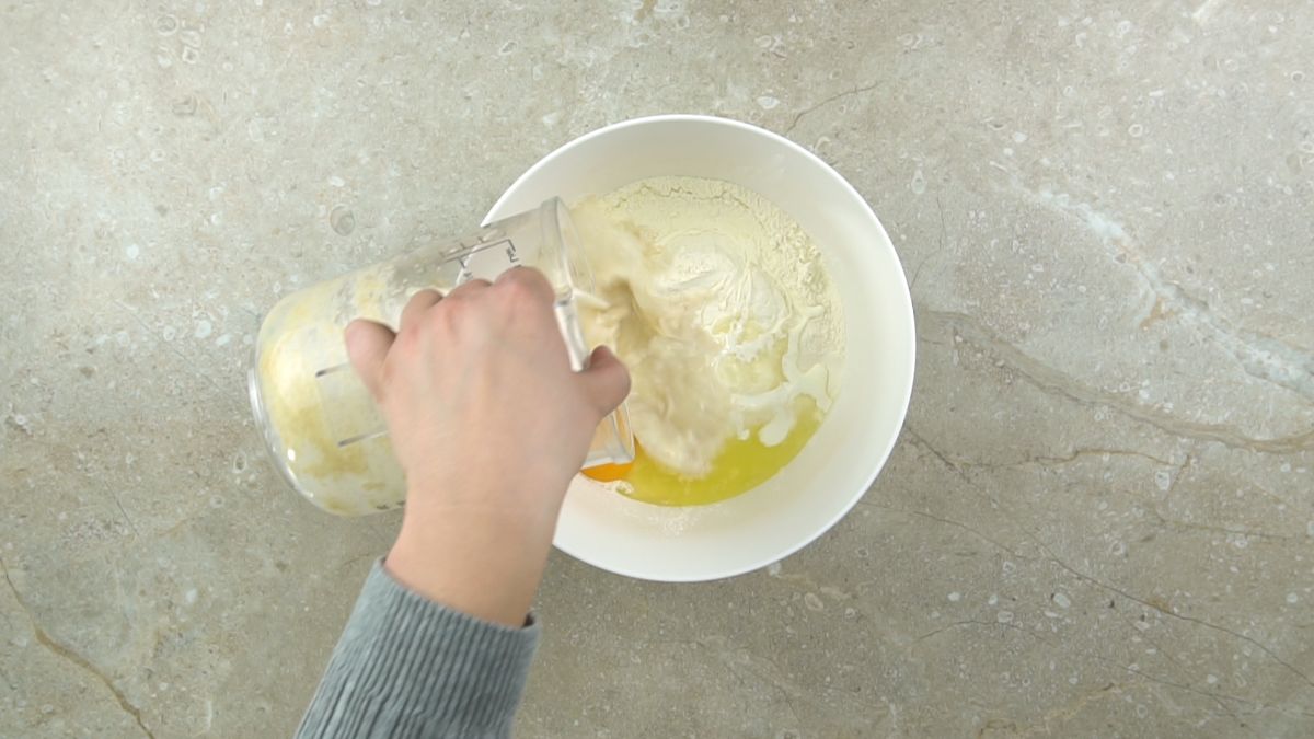 pouring yeast and milk into flour