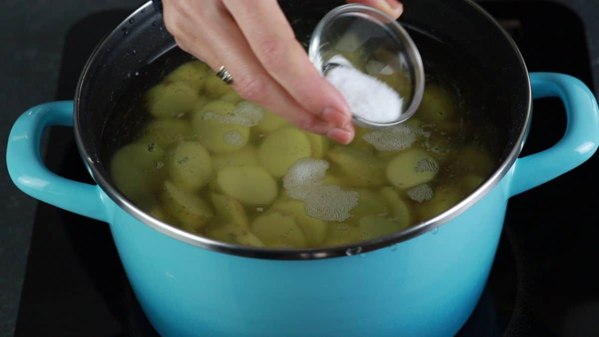 potatoes in blue stockpot with water being salted
