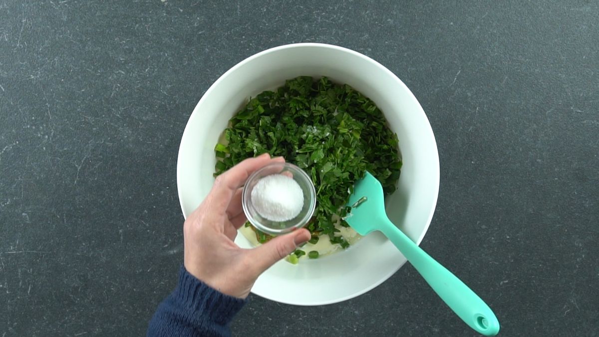 blue spoon in bowl with mayonnaise and fresh herbs