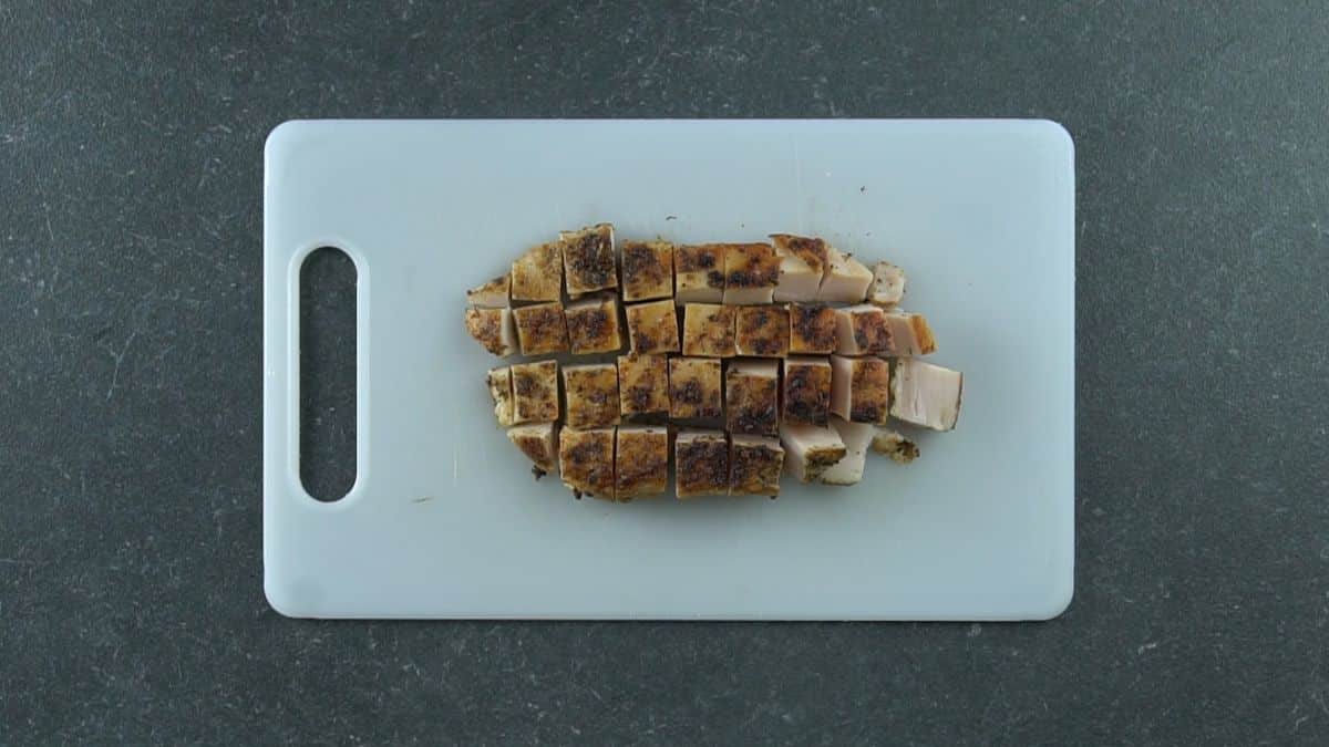 cooked chicken cut into chunks on cutting board