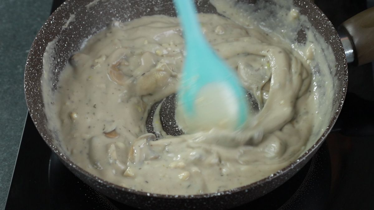 gravy being stirred in skillet with blue spoon