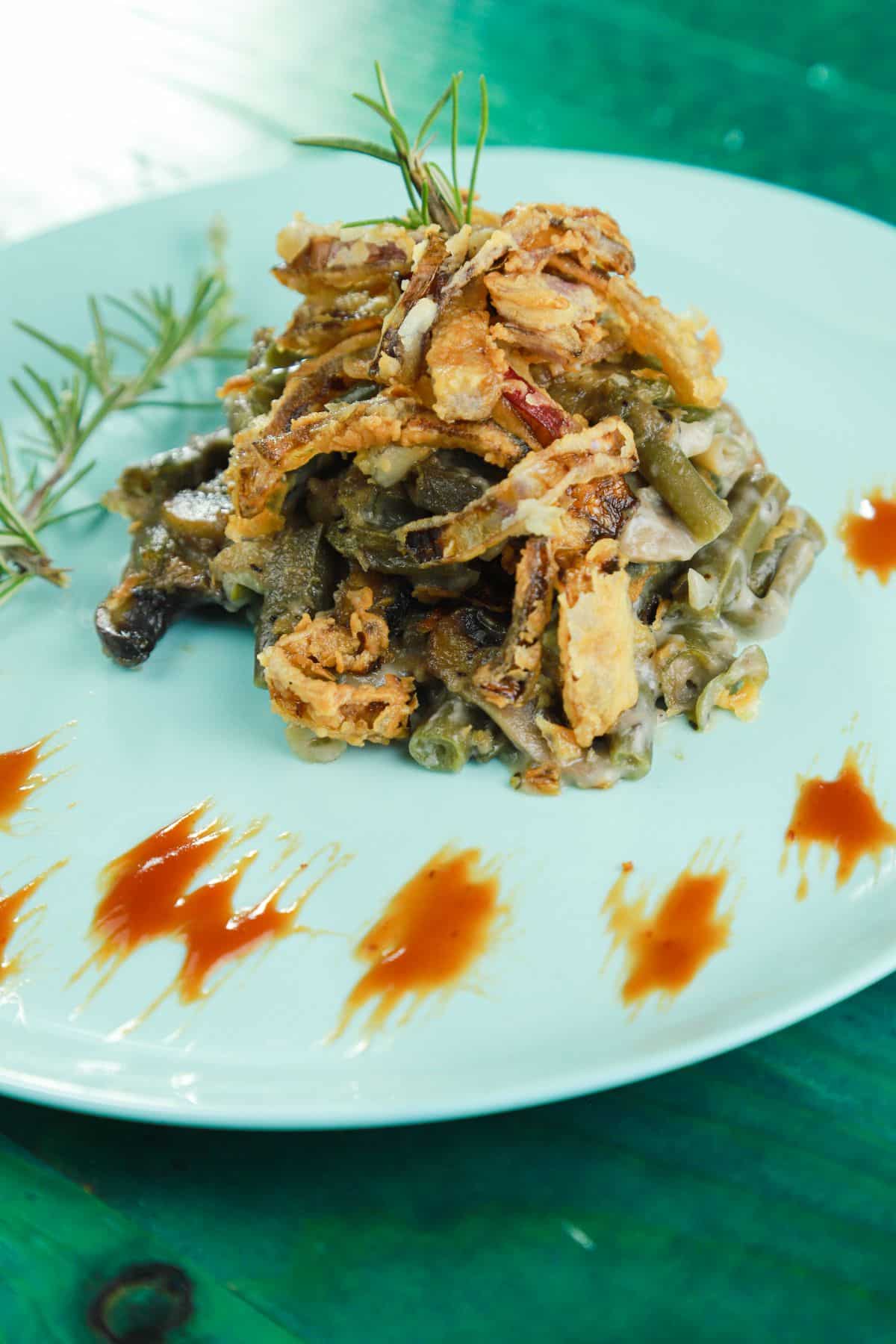 green bean casserole with crispy onion topping on blue plate