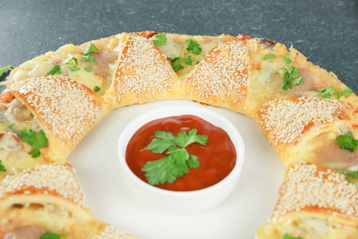 pizza sauce on white bowl in center of pizza ring