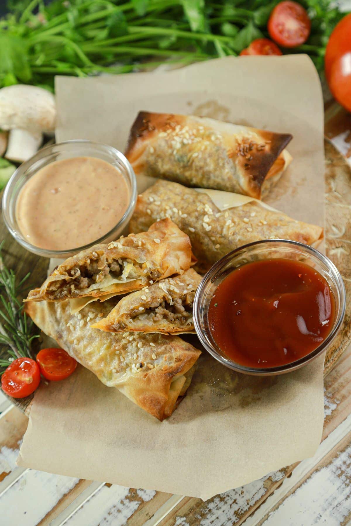 big mac eggrolls on parchment paper with dipping sauces in bowls